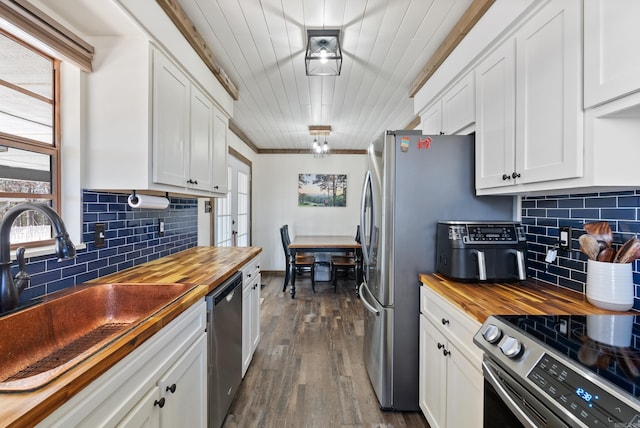 kitchen featuring a wealth of natural light, butcher block counters, stainless steel appliances, and a sink