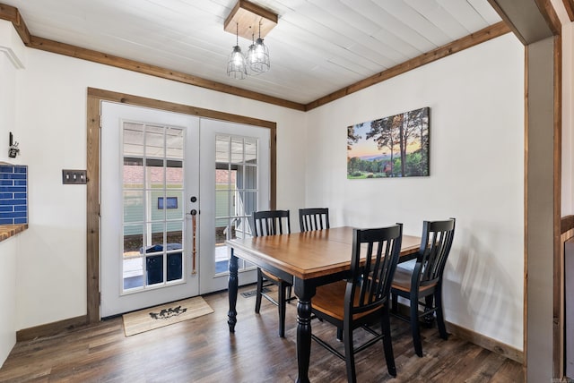 dining space with dark wood-type flooring, french doors, baseboards, and an inviting chandelier