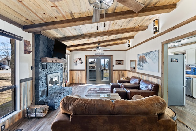 living area with wainscoting, wooden ceiling, wood finished floors, french doors, and a healthy amount of sunlight