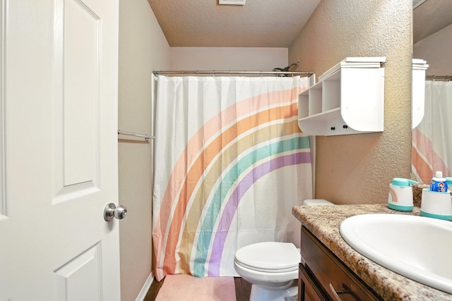 bathroom featuring curtained shower, a textured wall, vanity, and a textured ceiling