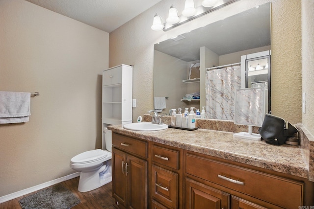 bathroom featuring baseboards, a shower with shower curtain, toilet, wood finished floors, and vanity