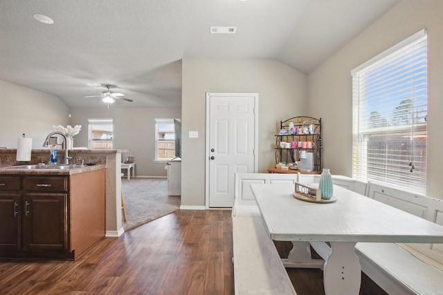 dining area with baseboards, visible vents, a ceiling fan, dark wood-style flooring, and vaulted ceiling