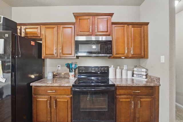 kitchen with light stone countertops, black appliances, and brown cabinetry