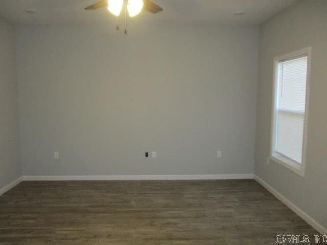 spare room with plenty of natural light, baseboards, and wood finished floors