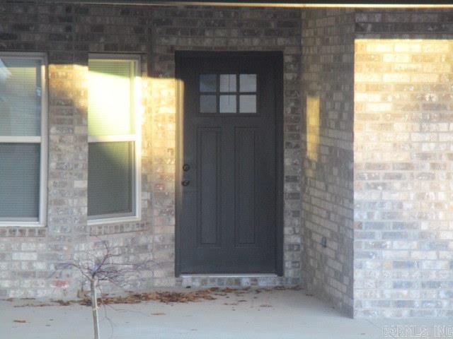 view of exterior entry featuring brick siding