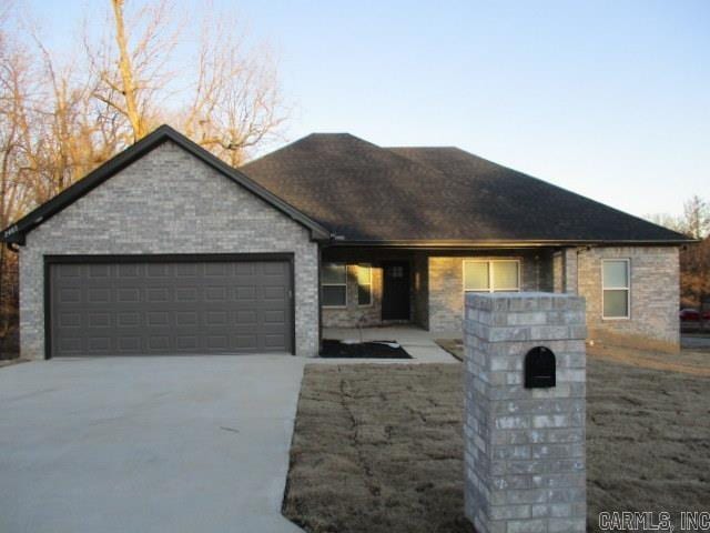 ranch-style home with an attached garage and concrete driveway