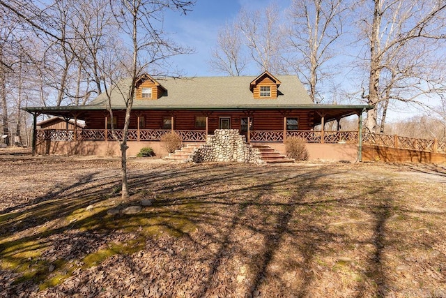 log cabin with stairway and a porch