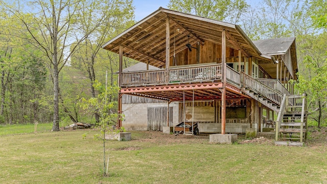 back of property featuring stairs and a lawn