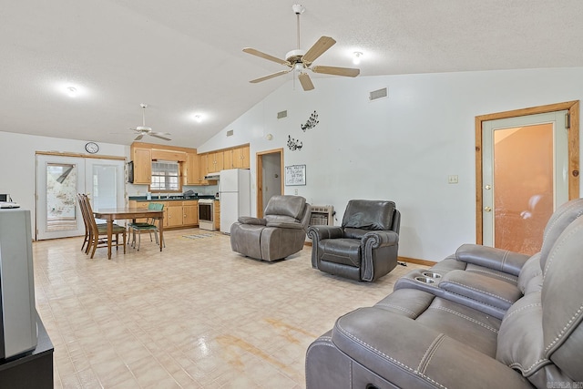 living area with a textured ceiling, high vaulted ceiling, visible vents, a ceiling fan, and light floors