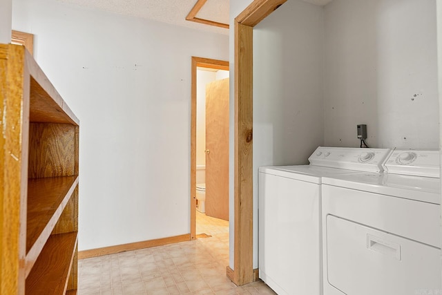 laundry room featuring light floors, laundry area, baseboards, and washing machine and clothes dryer