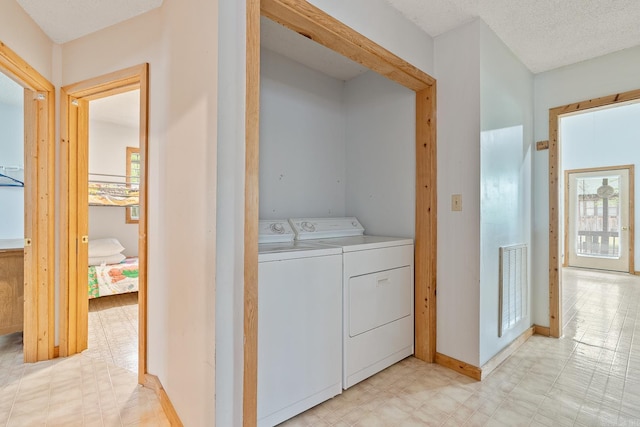 clothes washing area with light floors, visible vents, separate washer and dryer, laundry area, and baseboards