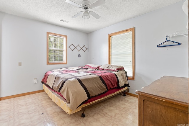 bedroom with a ceiling fan, visible vents, a textured ceiling, and light floors