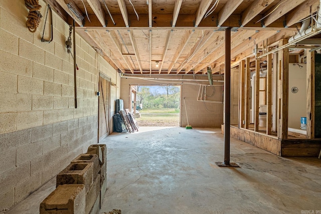 interior space featuring concrete floors and concrete block wall