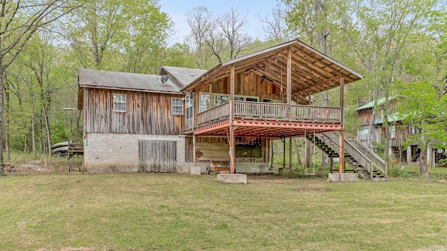 back of house featuring a yard, a deck, and stairs