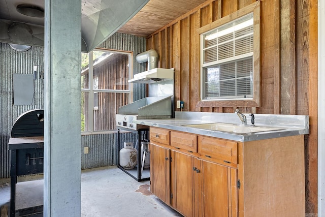 kitchen with open shelves, a sink, and unfinished concrete floors