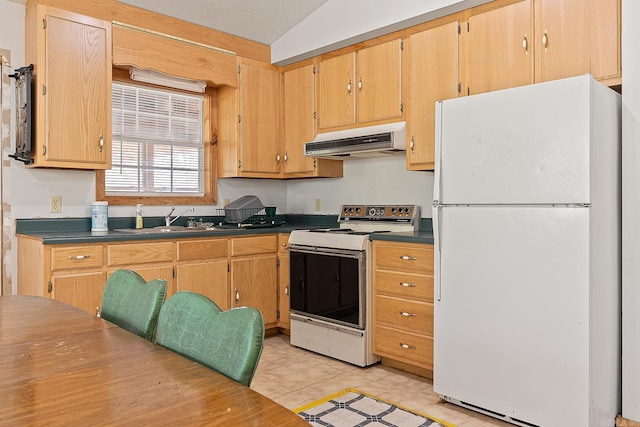 kitchen featuring dark countertops, white appliances, a sink, and under cabinet range hood