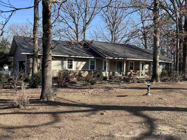 ranch-style house featuring covered porch and metal roof