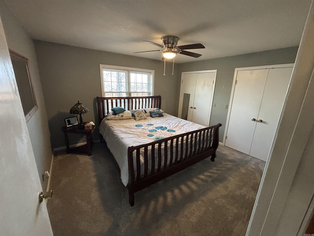 carpeted bedroom with ceiling fan and two closets