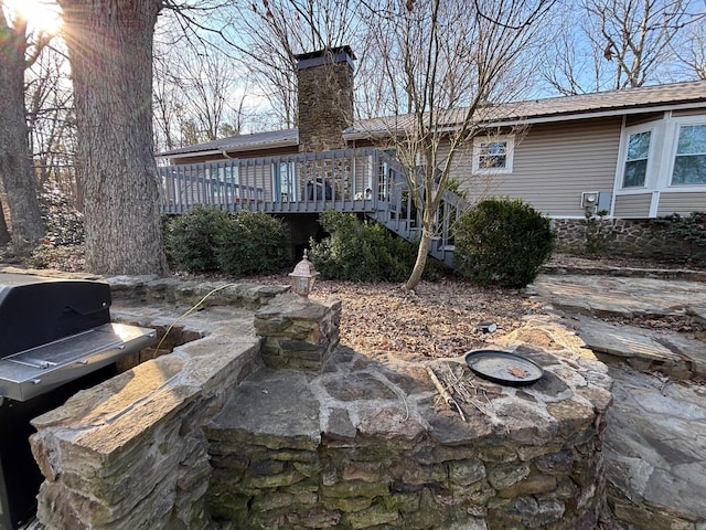 rear view of house featuring a chimney, metal roof, stairway, and a wooden deck