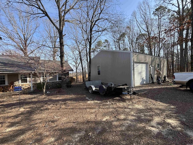 view of home's exterior with dirt driveway and an outbuilding