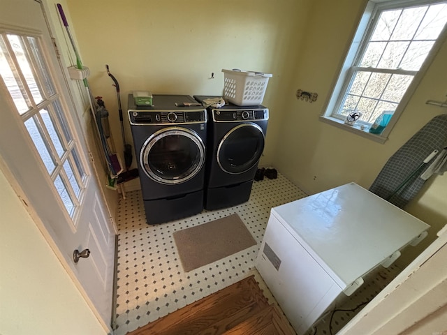 clothes washing area featuring laundry area, tile patterned floors, and washer and dryer