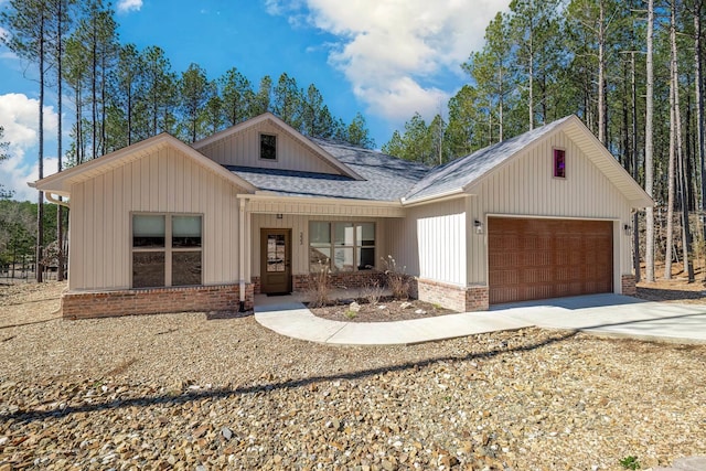 view of front facade featuring a garage, driveway, brick siding, and a shingled roof