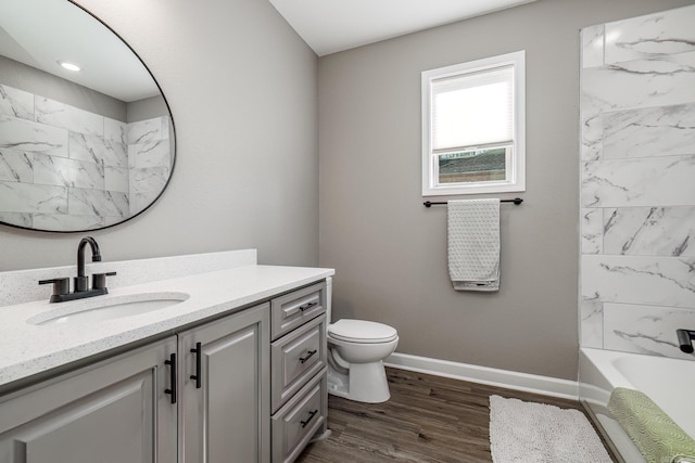 full bathroom featuring toilet, wood finished floors, vanity, and baseboards
