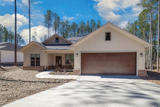 modern inspired farmhouse featuring a shingled roof, concrete driveway, brick siding, and an attached garage