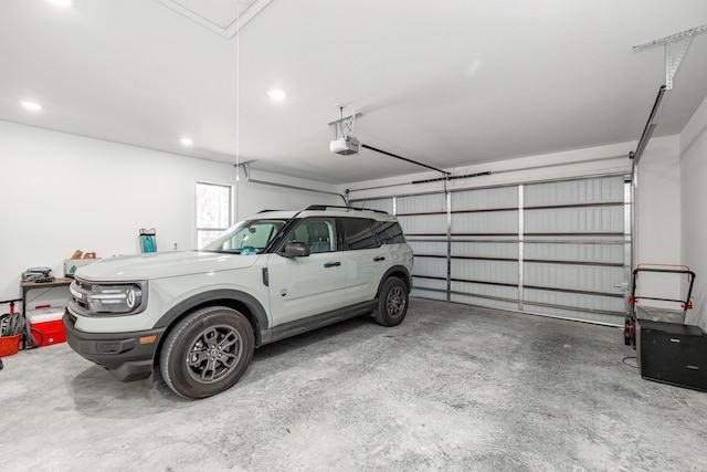 garage with recessed lighting and a garage door opener