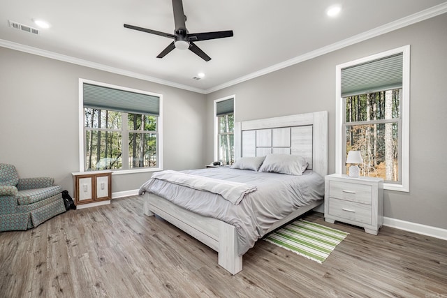 bedroom with baseboards, visible vents, and wood finished floors