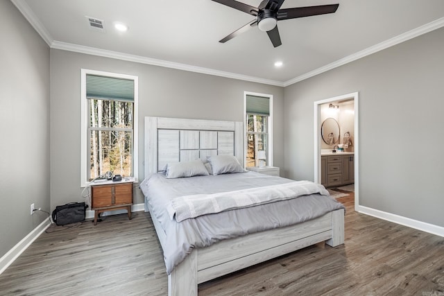 bedroom featuring crown molding, wood finished floors, visible vents, and baseboards