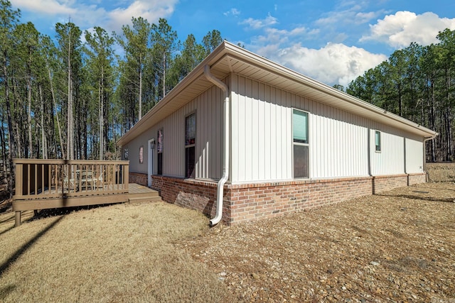 view of home's exterior with a deck and brick siding