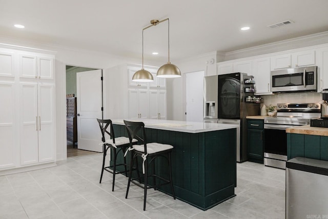 kitchen featuring stainless steel appliances, visible vents, light countertops, ornamental molding, and backsplash