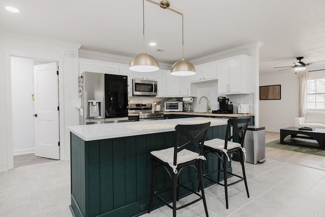 kitchen with appliances with stainless steel finishes, light countertops, a toaster, and tasteful backsplash