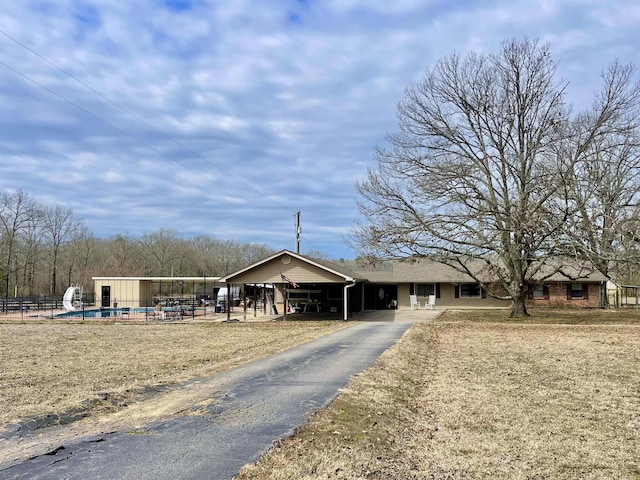 view of front of property featuring aphalt driveway and fence