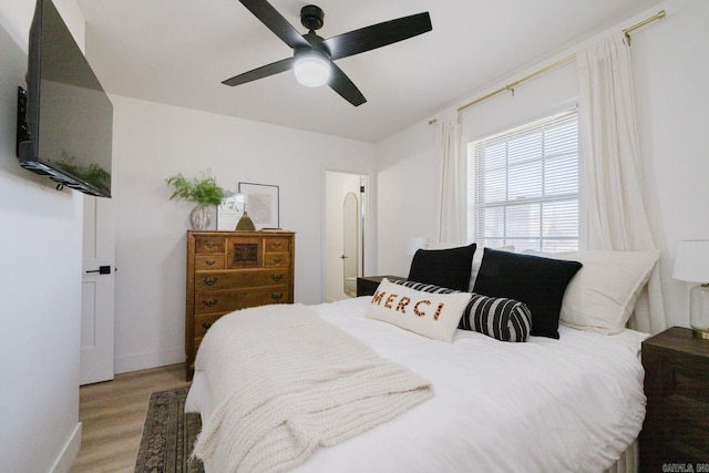 bedroom with baseboards, ceiling fan, and light wood finished floors