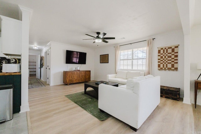 living area featuring light wood-style floors, ceiling fan, and ornamental molding