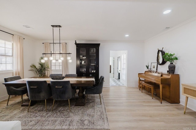 dining space featuring ornamental molding, recessed lighting, baseboards, and light wood finished floors