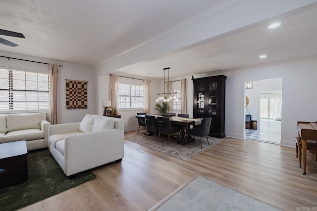 living room with ornamental molding, recessed lighting, baseboards, and wood finished floors