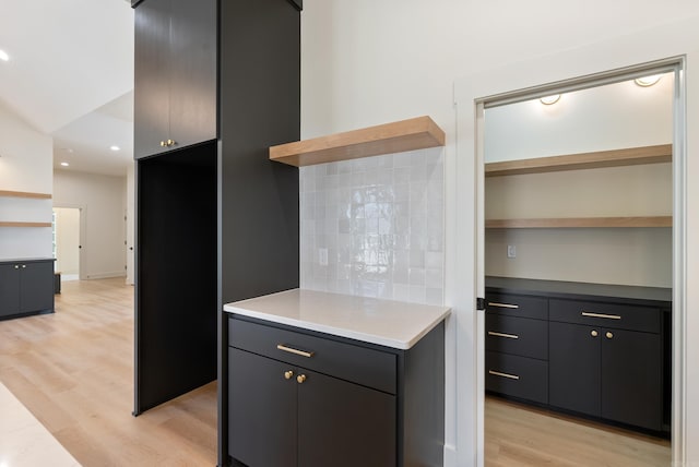 kitchen with open shelves, modern cabinets, light countertops, and light wood-style flooring