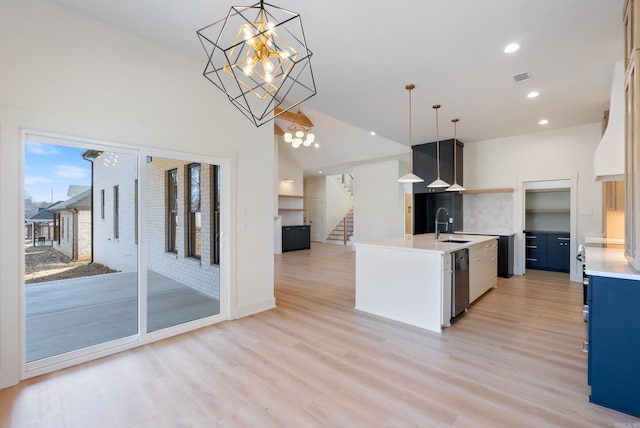 kitchen featuring a chandelier, light countertops, light wood finished floors, and pendant lighting