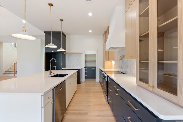 kitchen with stainless steel dishwasher, light wood-style floors, premium range hood, a sink, and range with electric stovetop