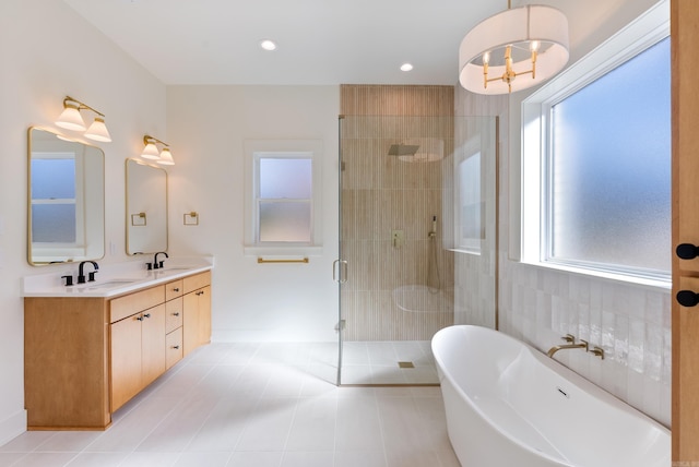 full bath with double vanity, a soaking tub, a sink, and a stall shower