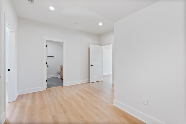 unfurnished bedroom with light wood-type flooring, baseboards, and recessed lighting