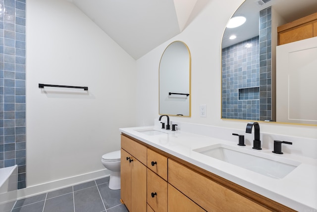 bathroom with double vanity, tile patterned flooring, a sink, and toilet