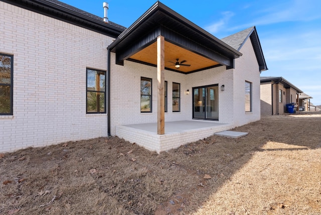 back of property featuring a patio area, ceiling fan, and brick siding