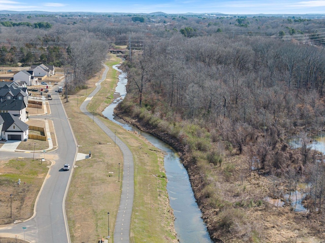 birds eye view of property featuring a water view and a view of trees