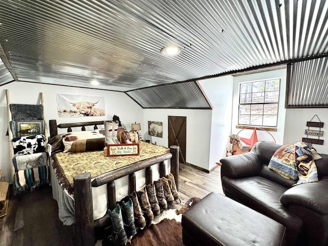 bedroom with lofted ceiling and wood finished floors