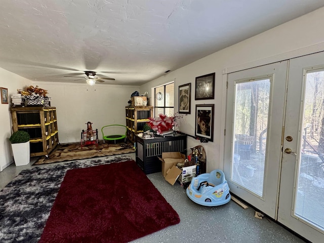 interior space with a ceiling fan, french doors, and a textured ceiling