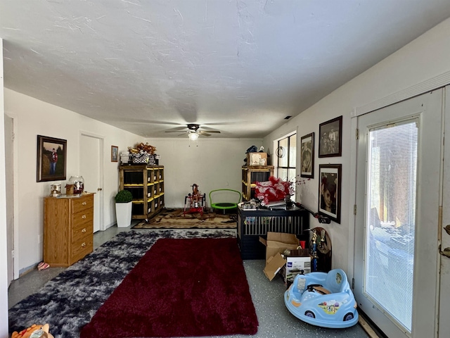 interior space with ceiling fan and a textured ceiling